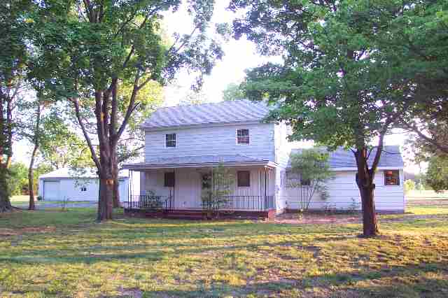 a view of a house with a tree in front of it