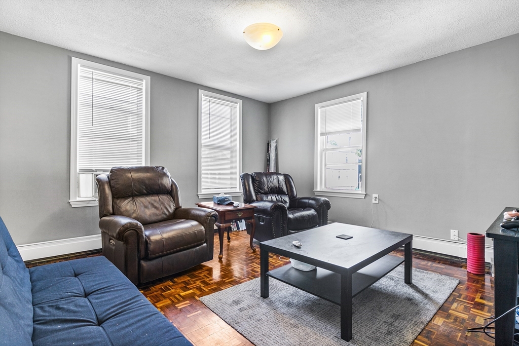 a living room with furniture a rug and a window