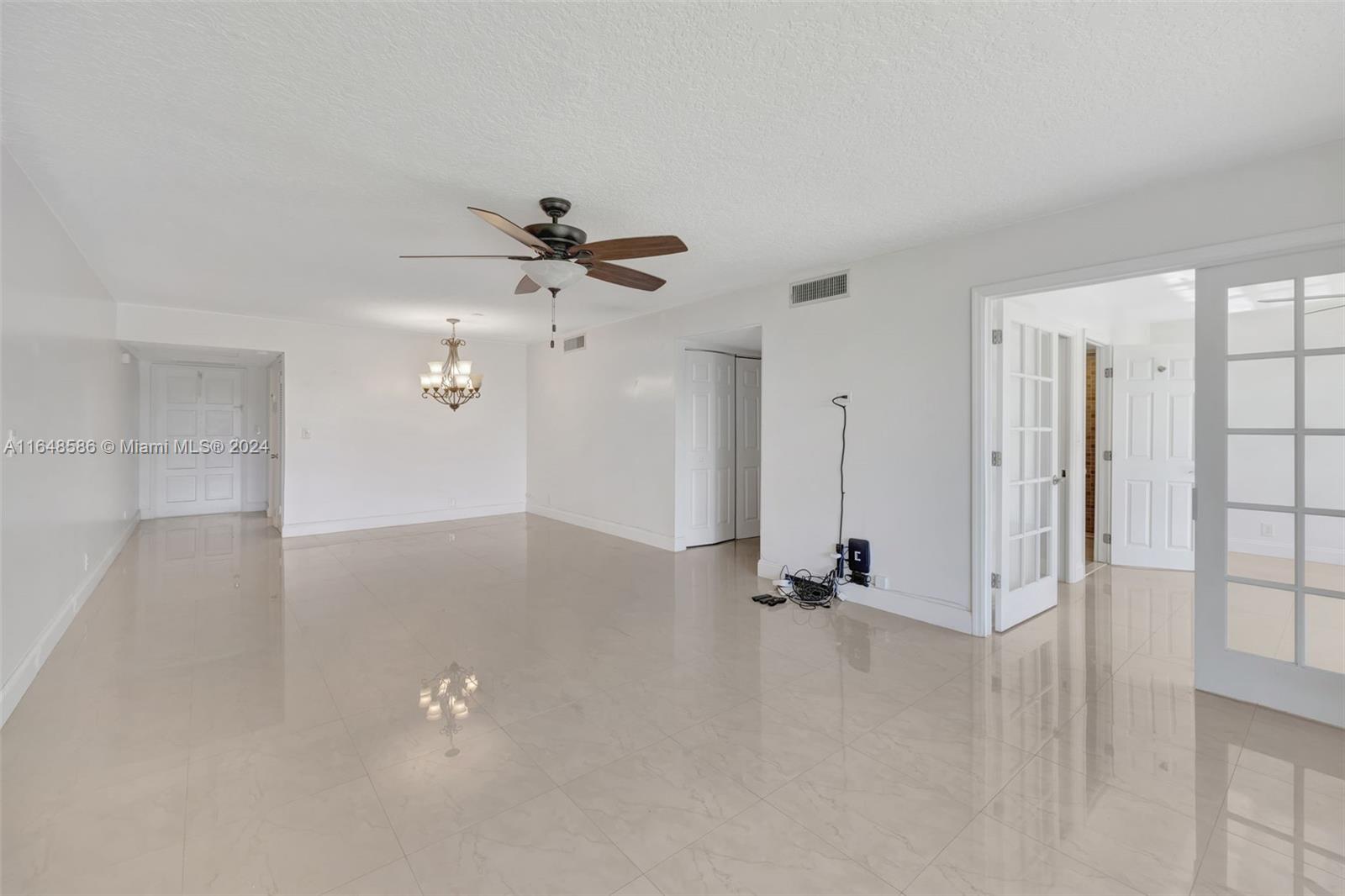 a view of a room with a ceiling fan and window