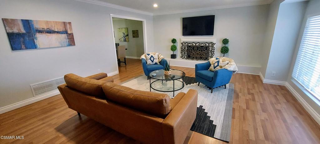 a living room with furniture a fireplace and a flat screen tv