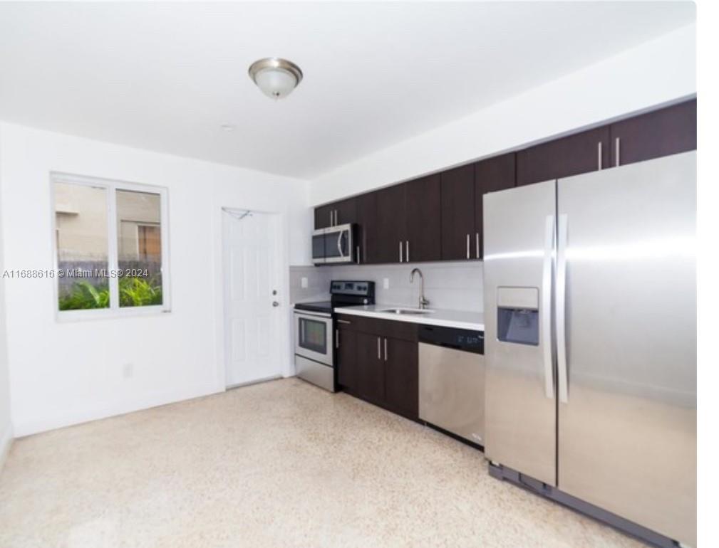 a large kitchen with cabinets and stainless steel appliances