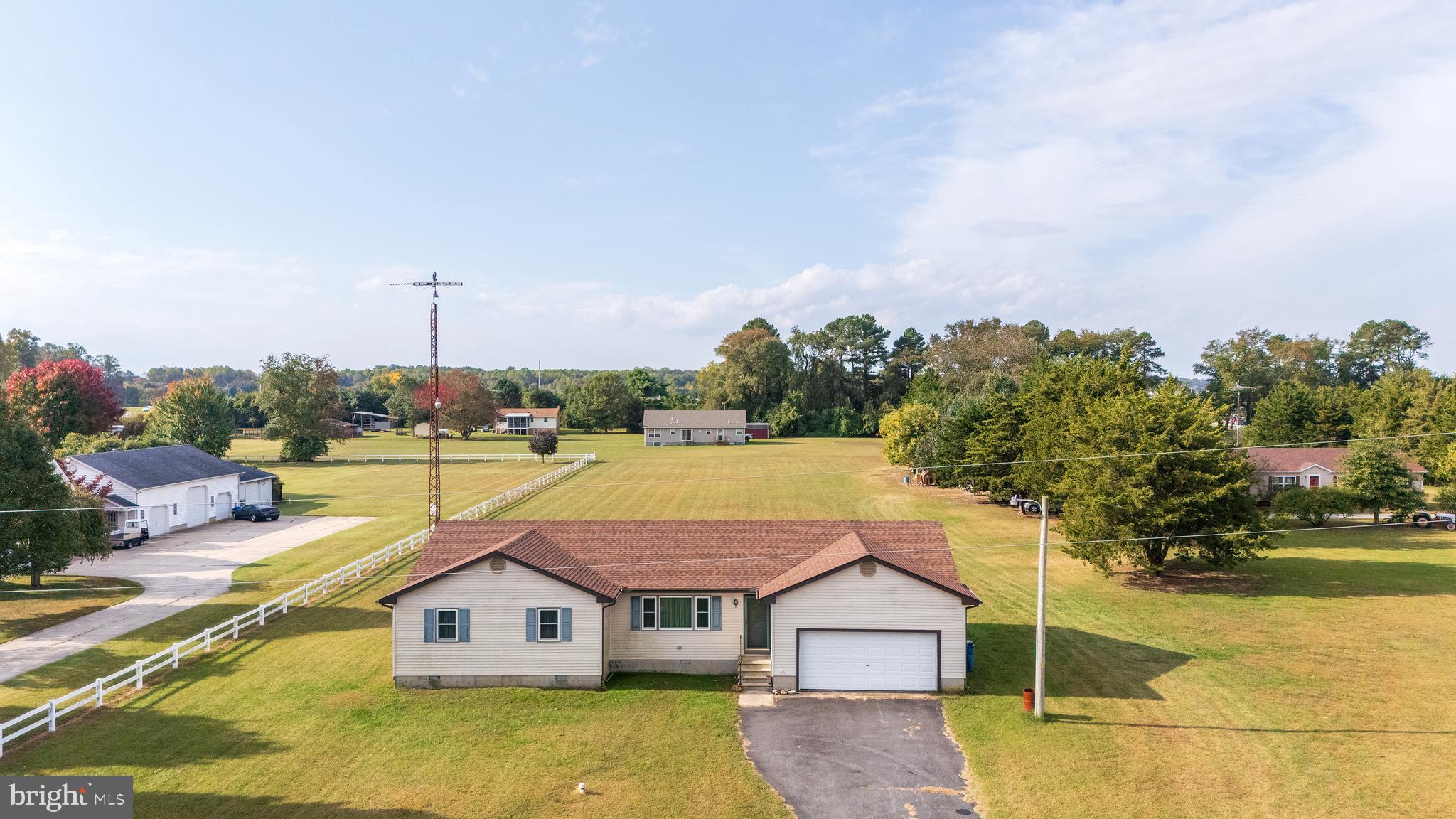 an aerial view of a house with swimming pool and large trees