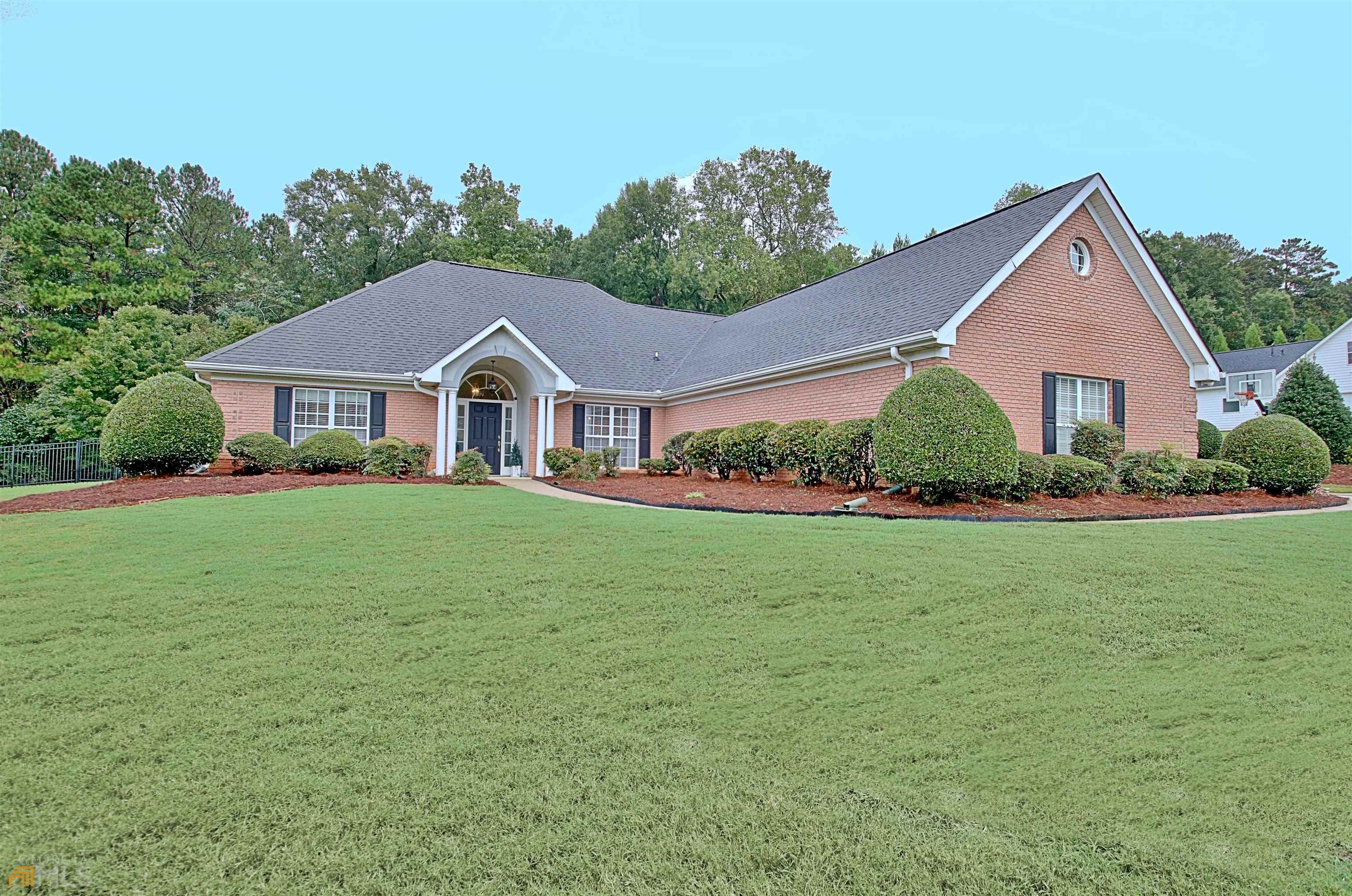 a front view of a house with a yard and potted plants