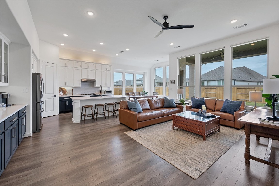 a living room with stainless steel appliances kitchen island granite countertop a couch and a view of kitchen