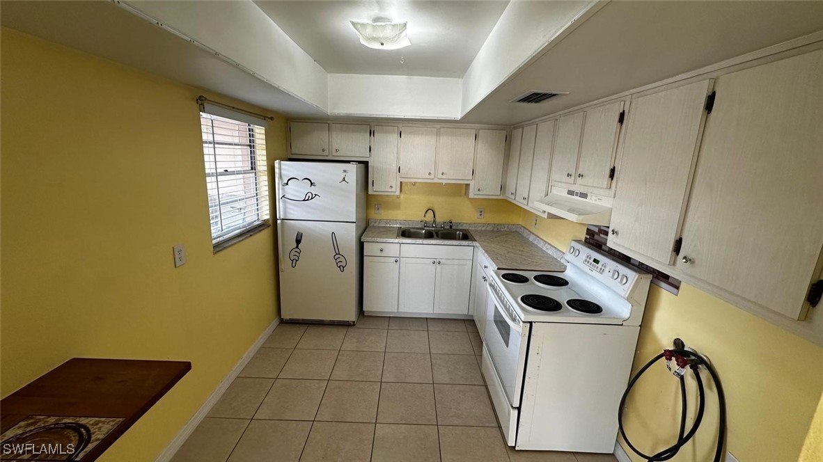 a kitchen with a stove a refrigerator and a sink