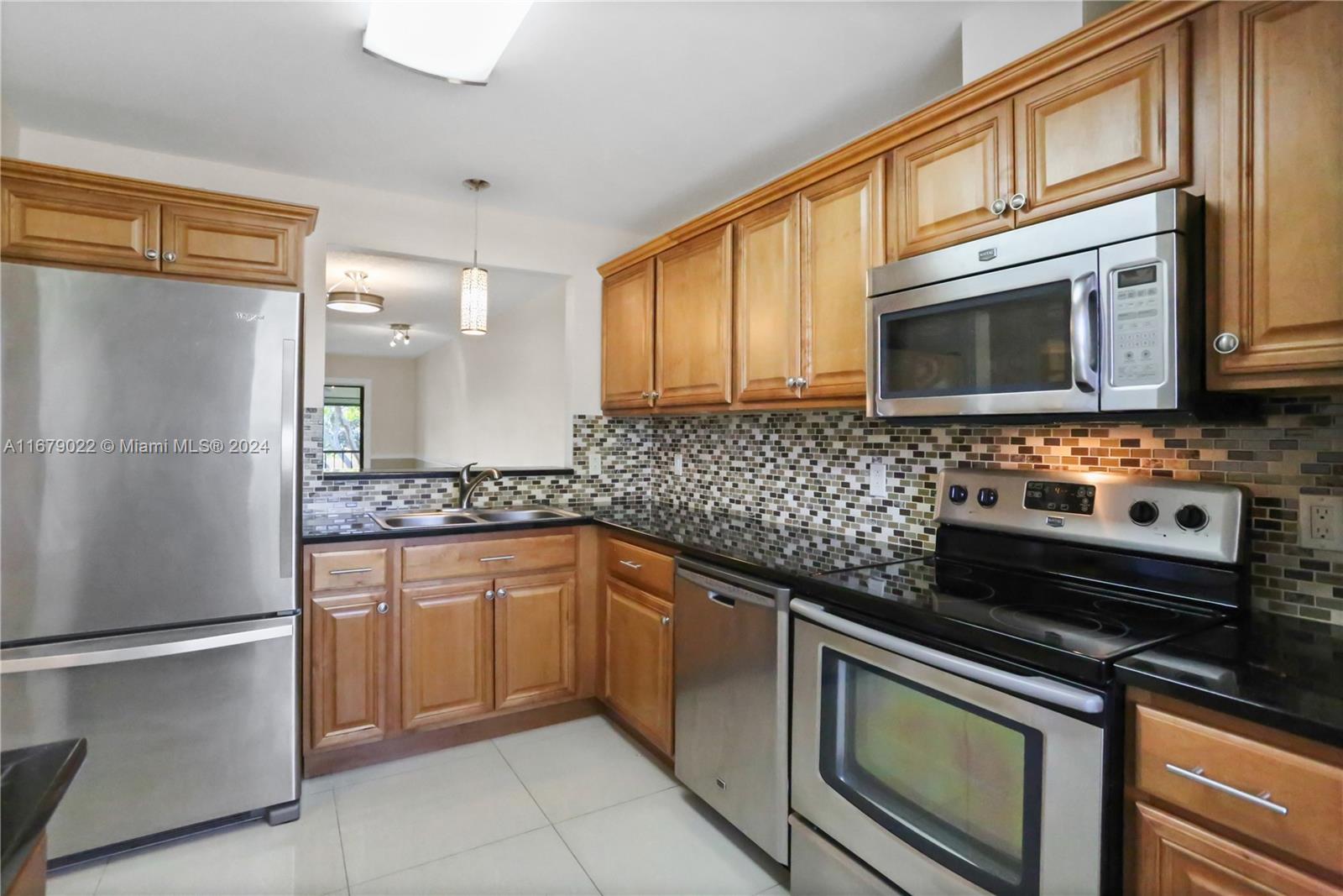 a kitchen with granite countertop a refrigerator stove and microwave