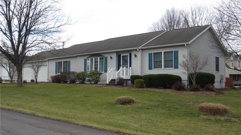 a front view of a house with a yard and trees