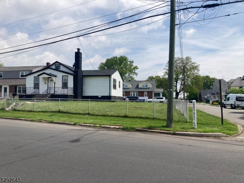 a view of a house with a big yard plants and palm trees