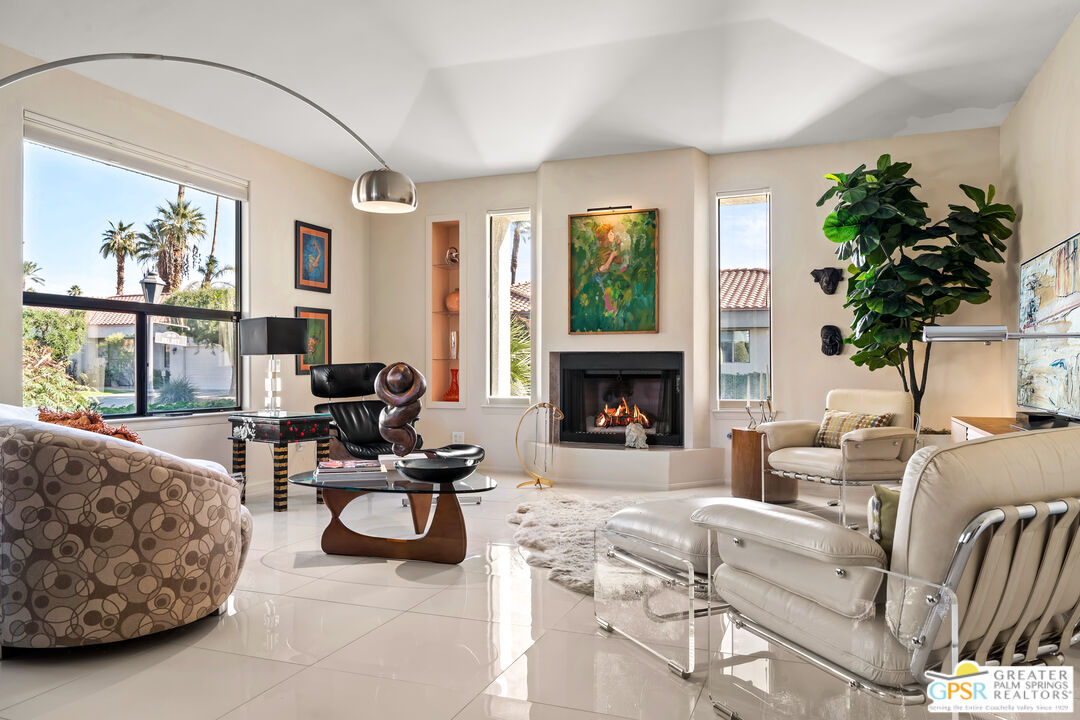 a living room with furniture a large window and a fireplace