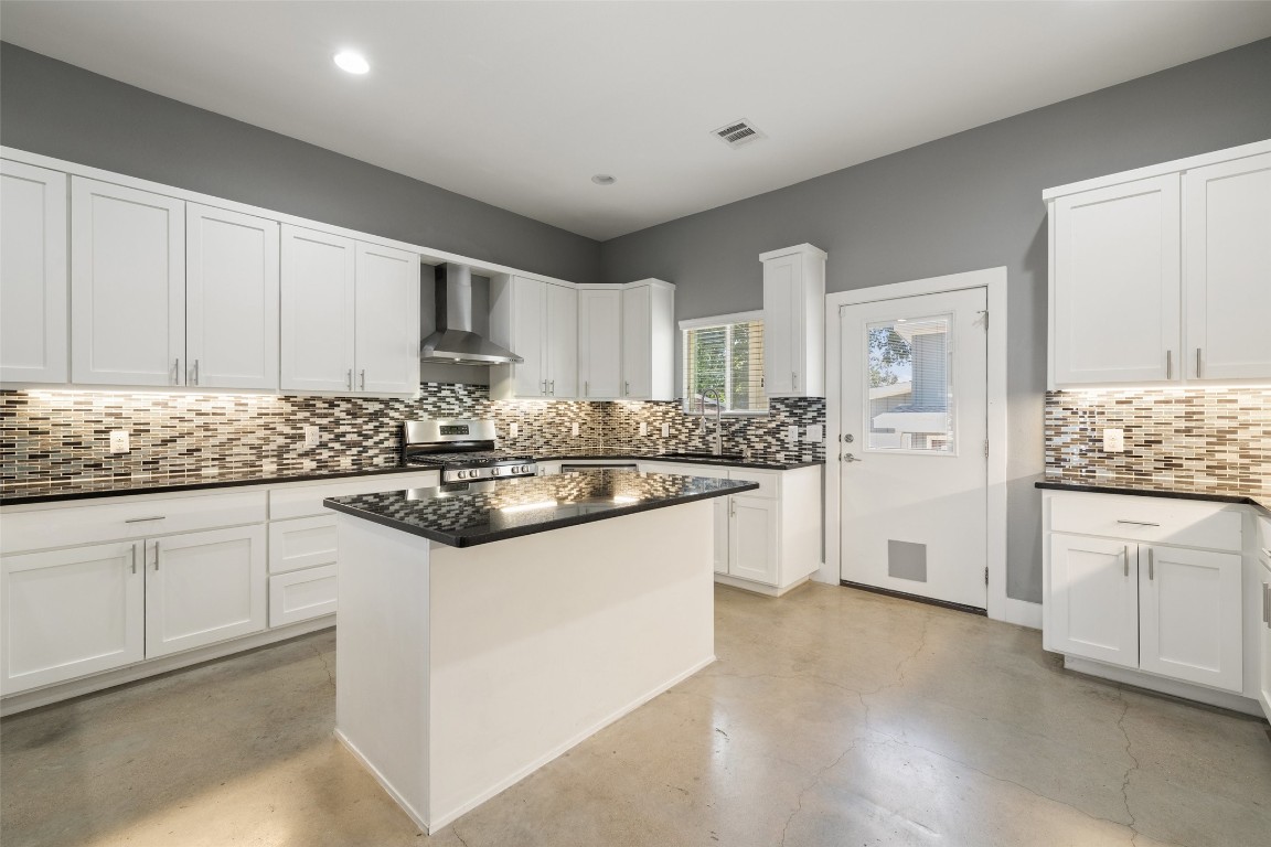 a kitchen with granite countertop white cabinets and white appliances