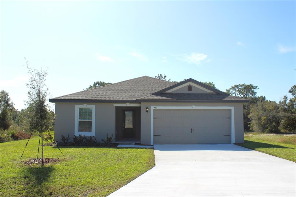 a front view of a house with a yard and a garage