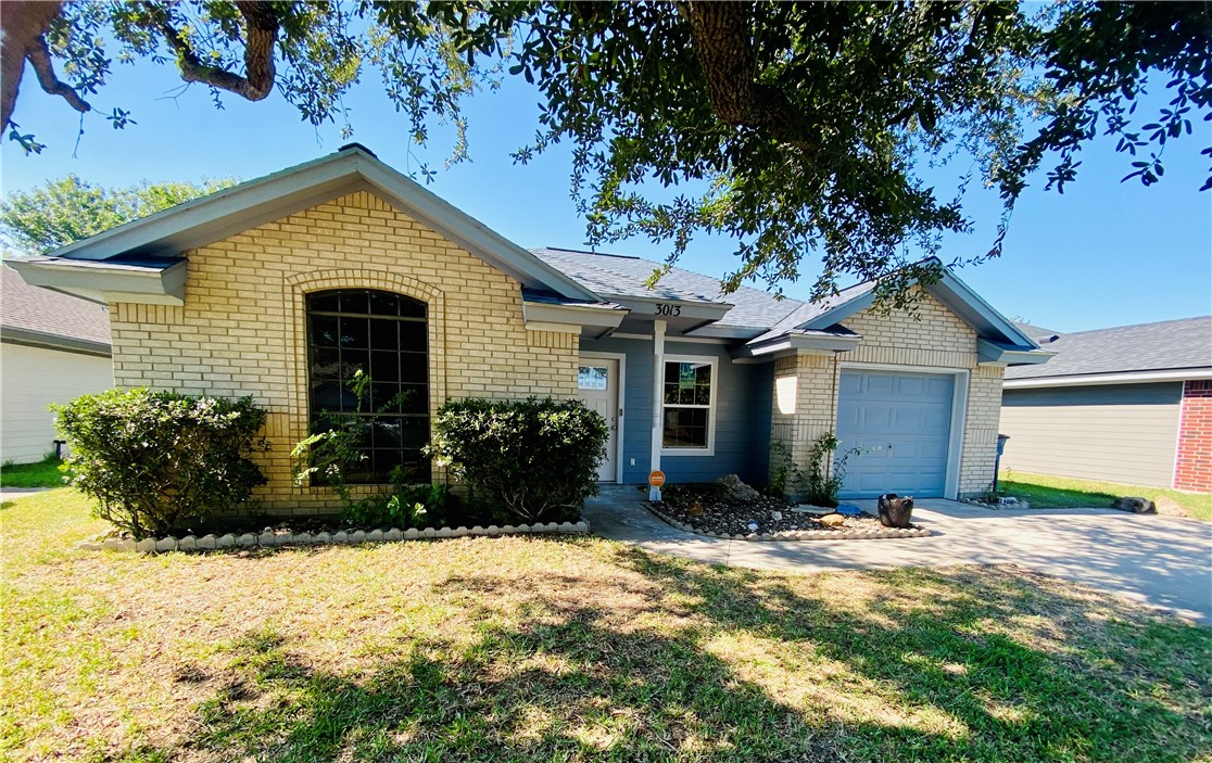 a front view of house with yard and trees in the background