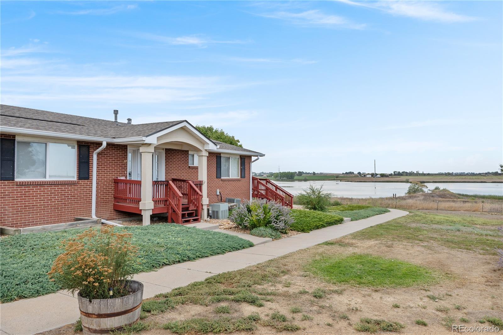 a front view of a house with a yard and lake view