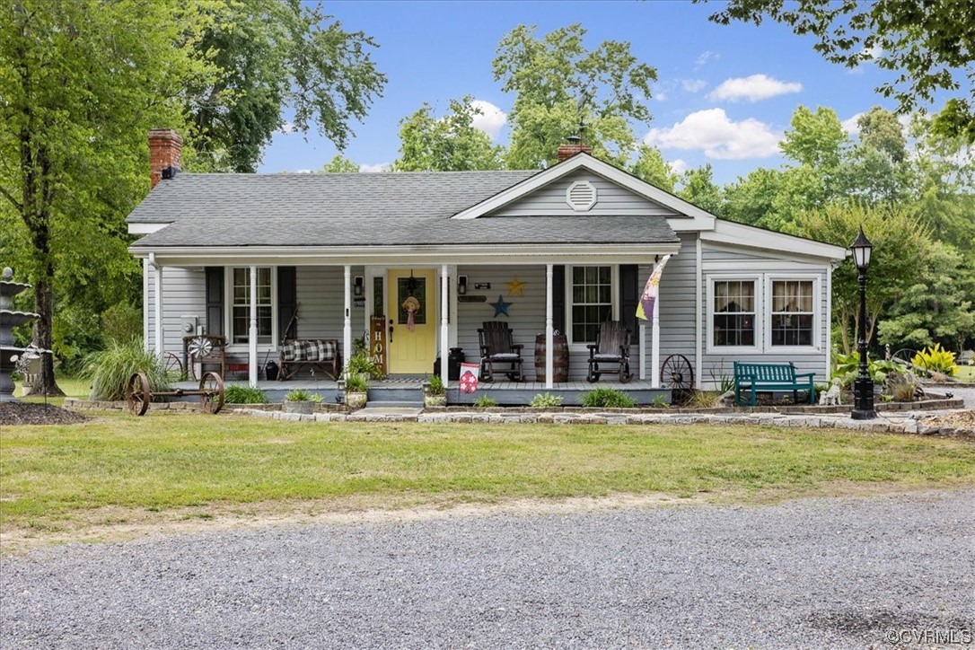 a view of a house with a yard potted plants and a large tree