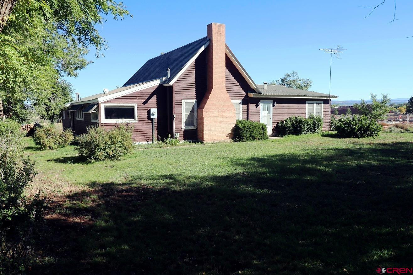 a view of a house with backyard and garden