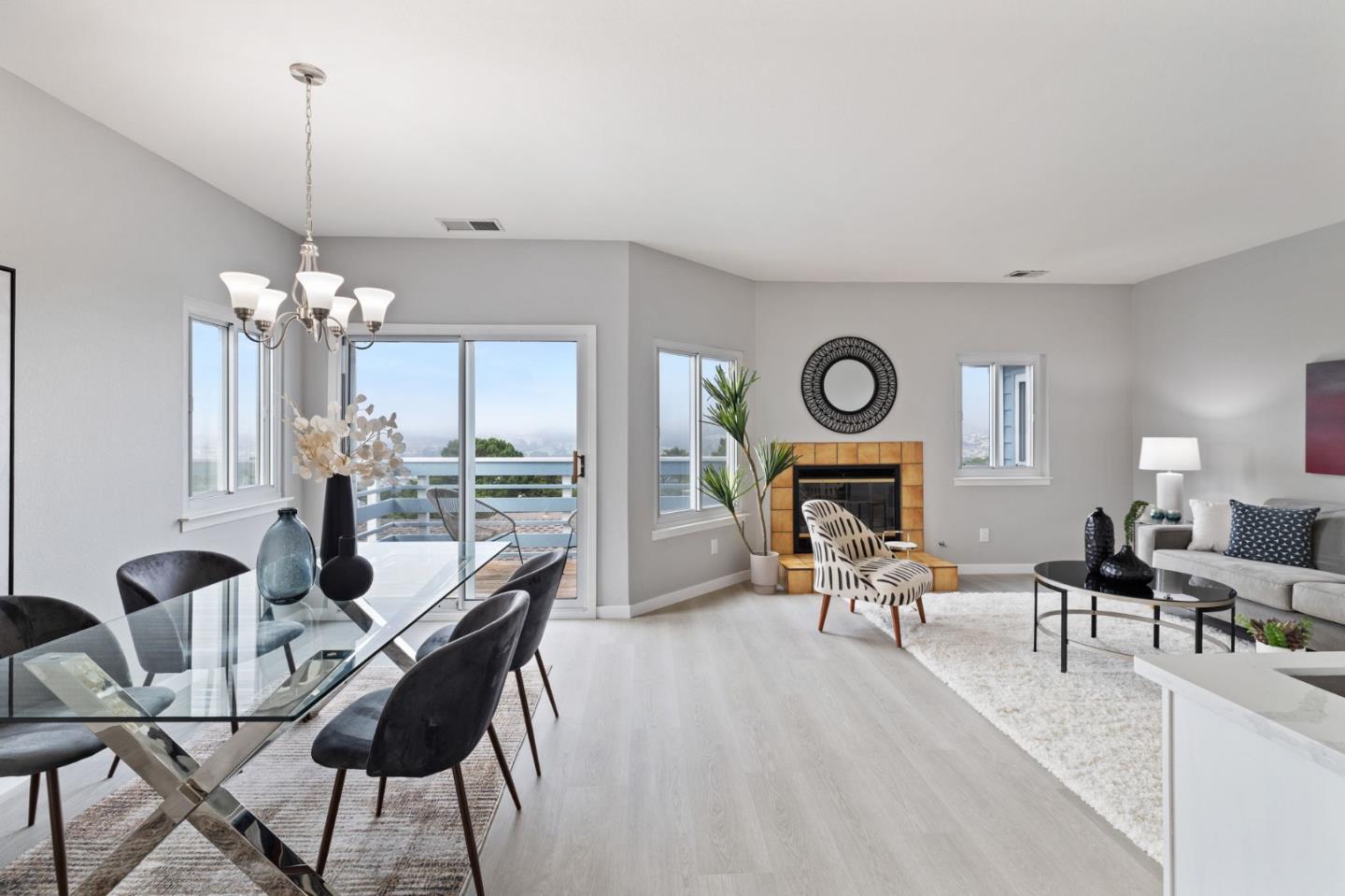 a living room with furniture a chandelier and a fireplace