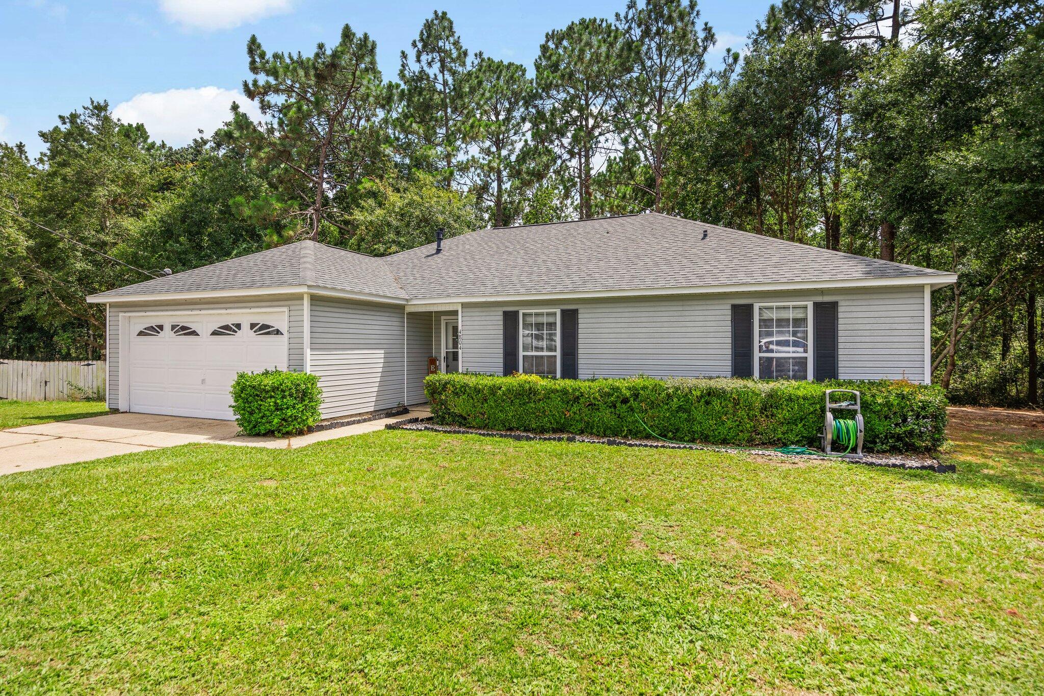 a front view of a house with yard and green space