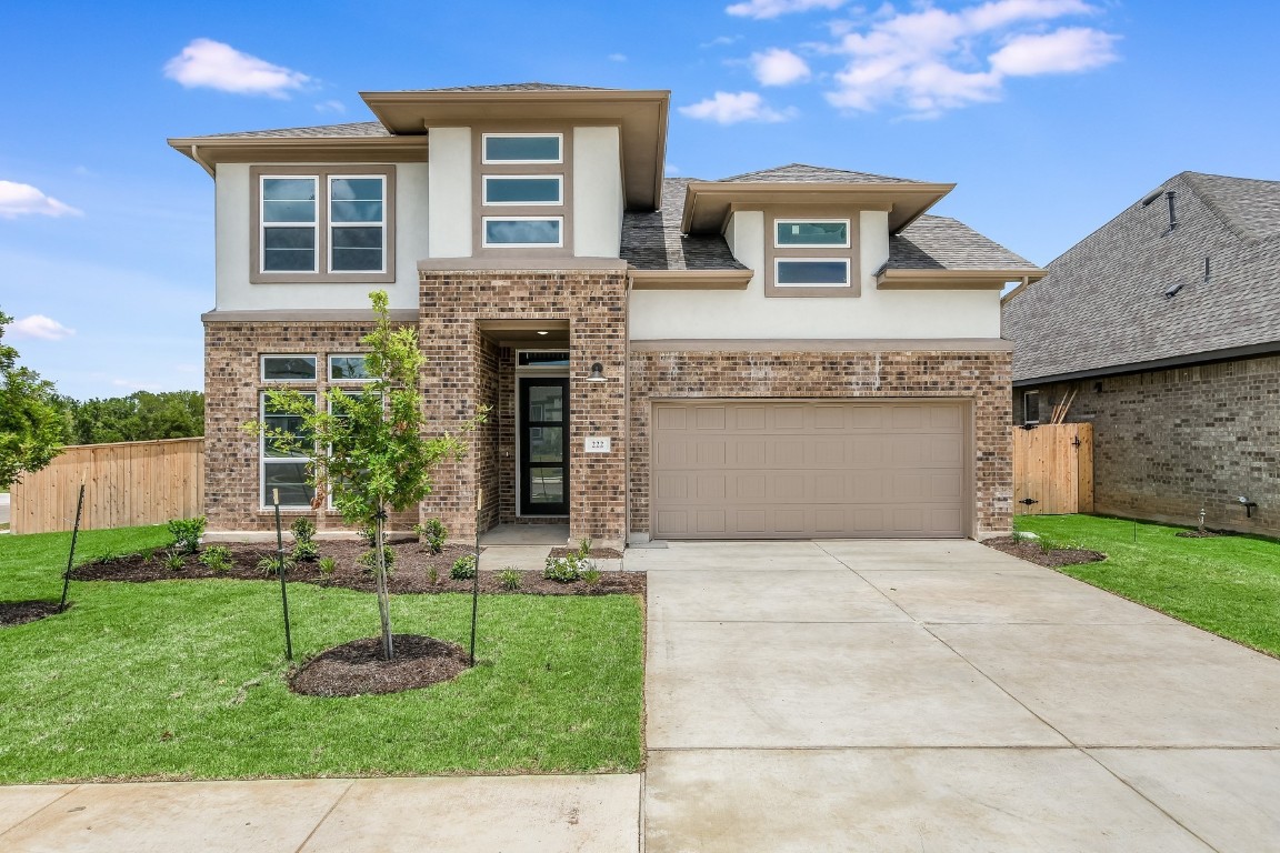 a front view of a house with a yard and garage