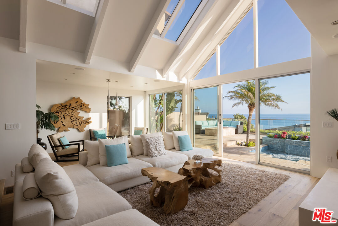 a living room with furniture fireplace and a large window