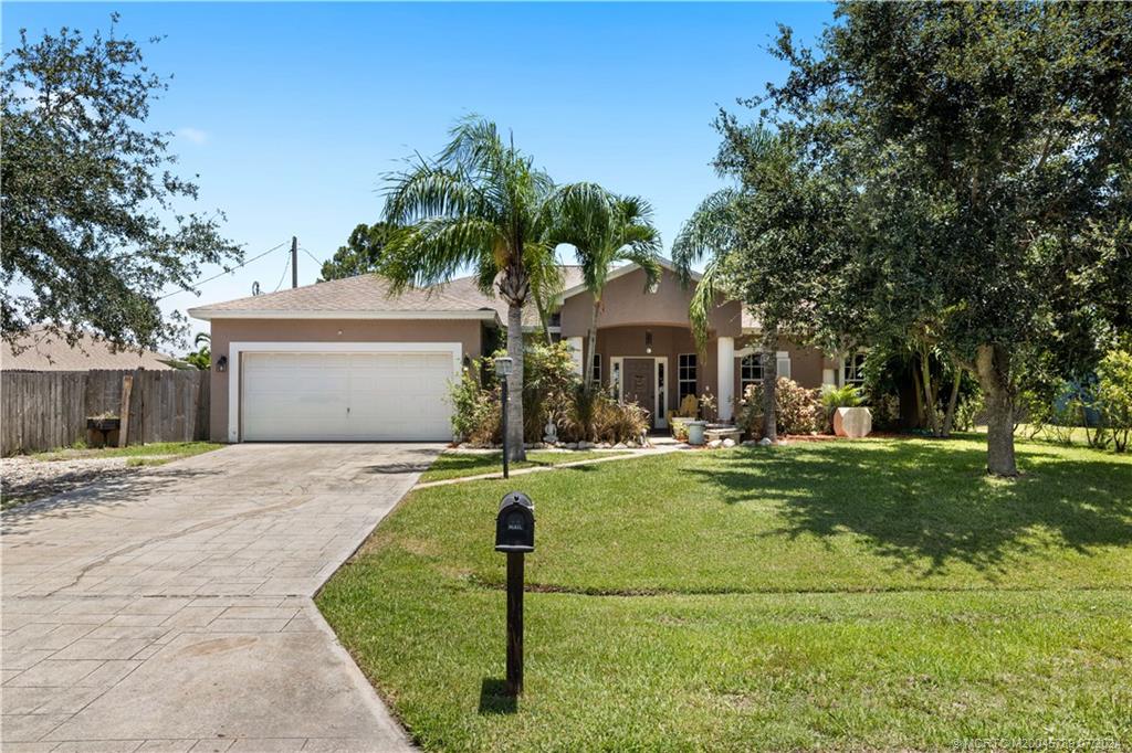 a front view of a house with a yard garage and outdoor seating