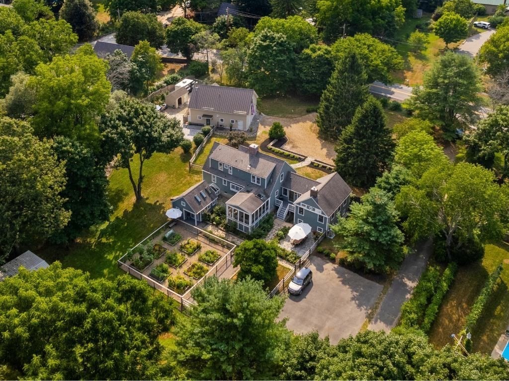 an aerial view of residential house with outdoor space and trees all around