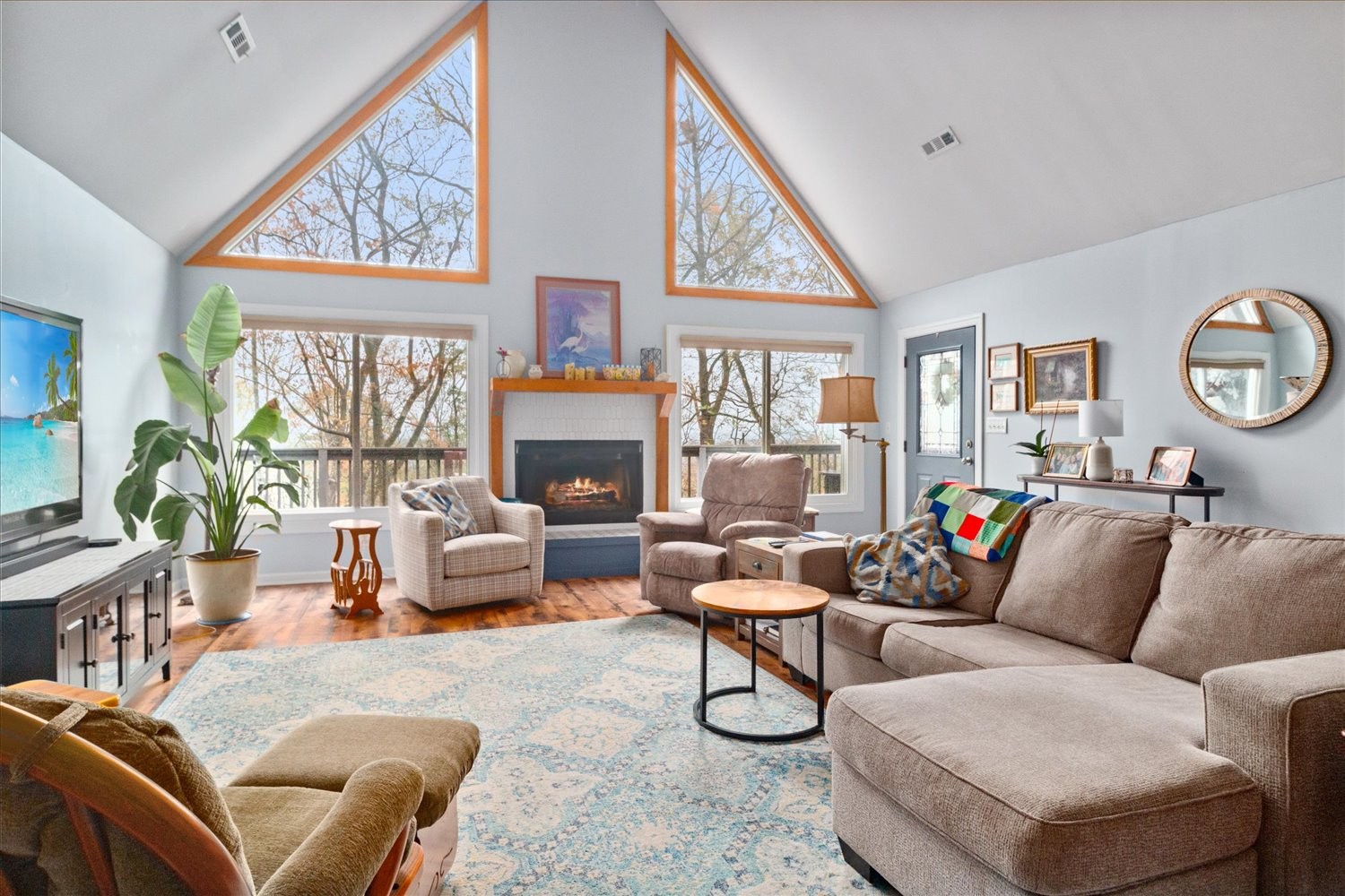 a living room with furniture a fireplace and a large window