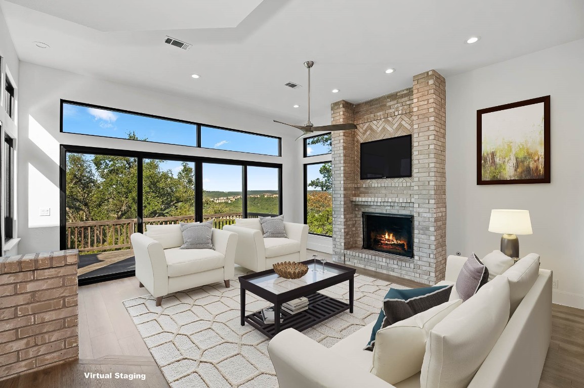 a living room with furniture fireplace and a large window