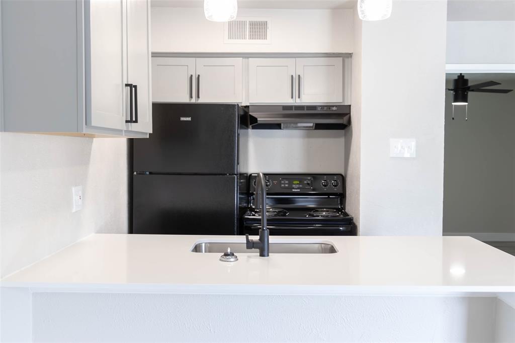 a kitchen with a refrigerator and a stove