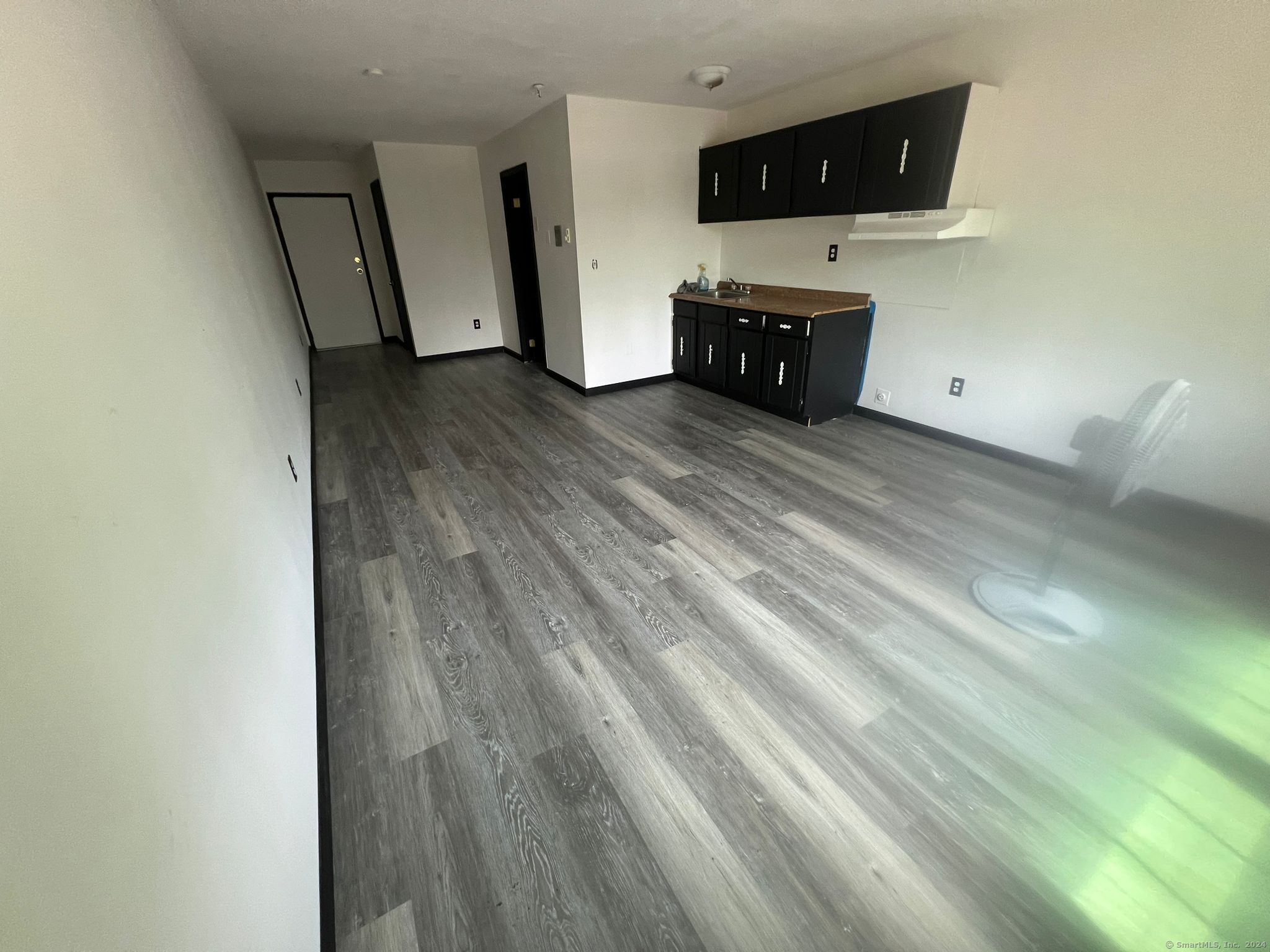 an empty room with wooden floor and mirror