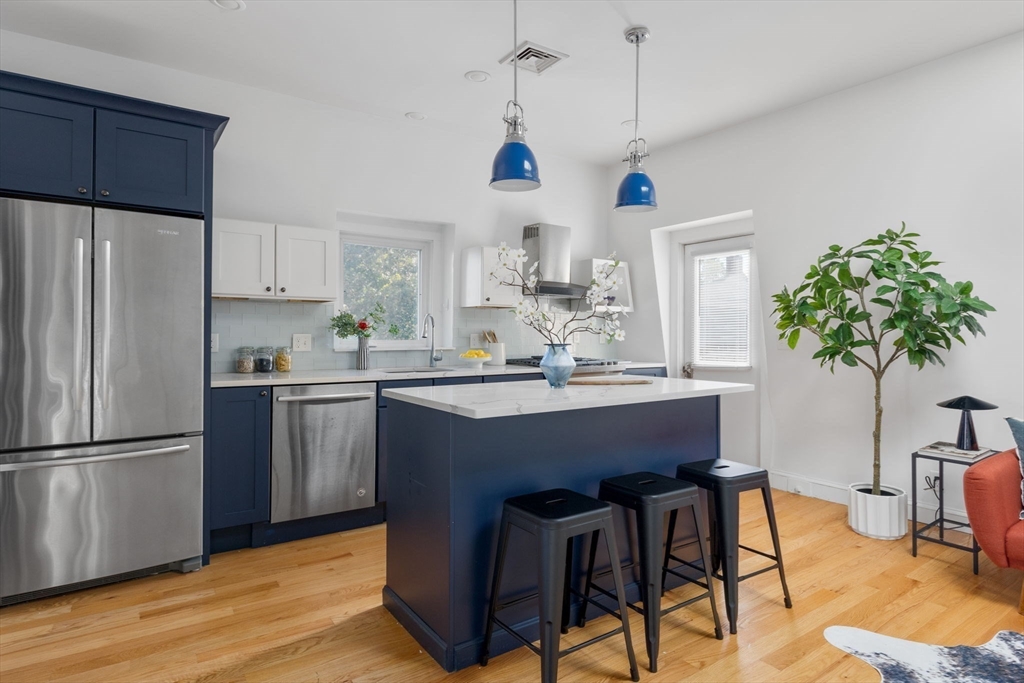 a kitchen with kitchen island a counter space a sink appliances and cabinets