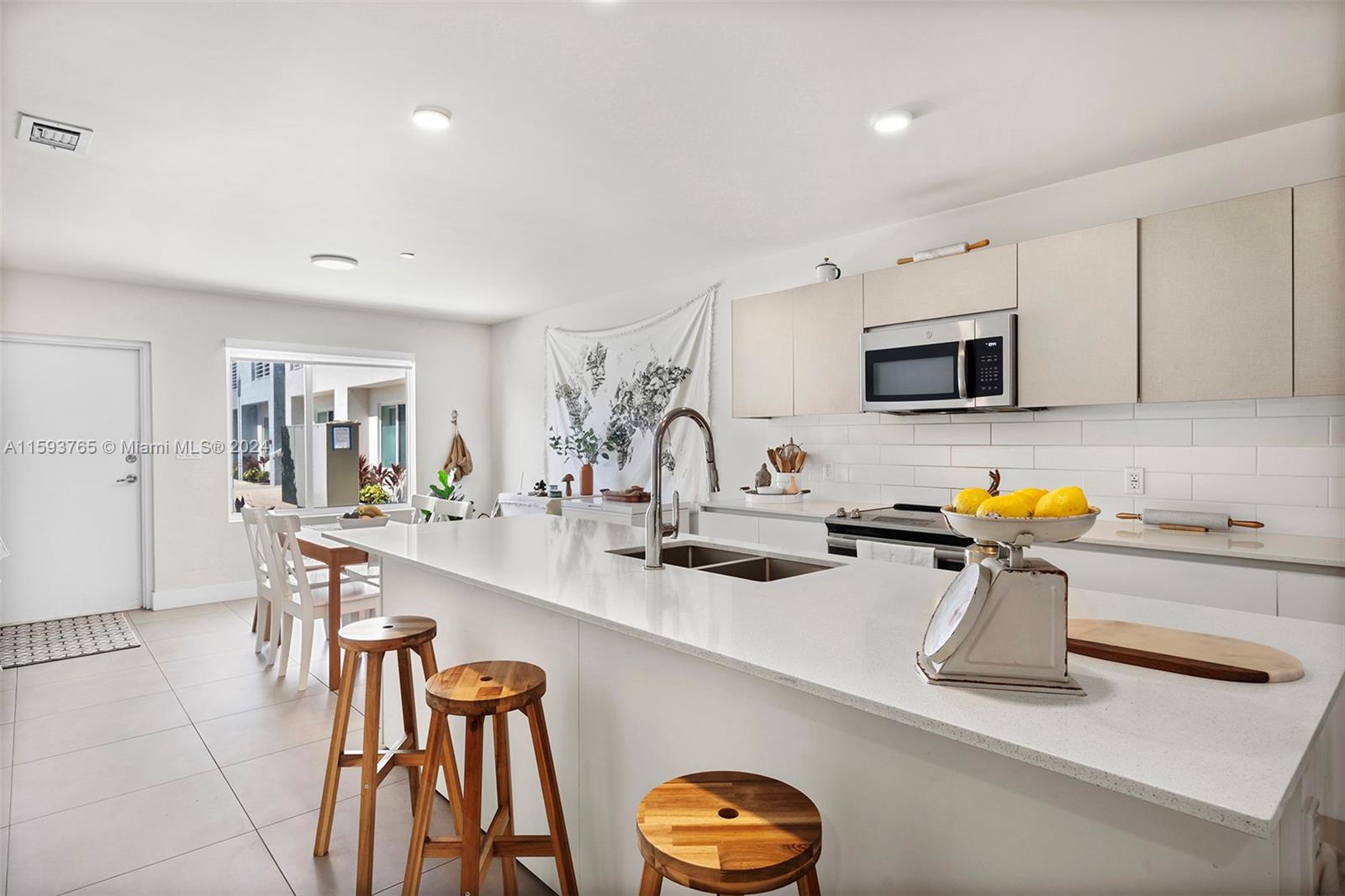 a kitchen with stainless steel appliances a sink a stove a table and chairs