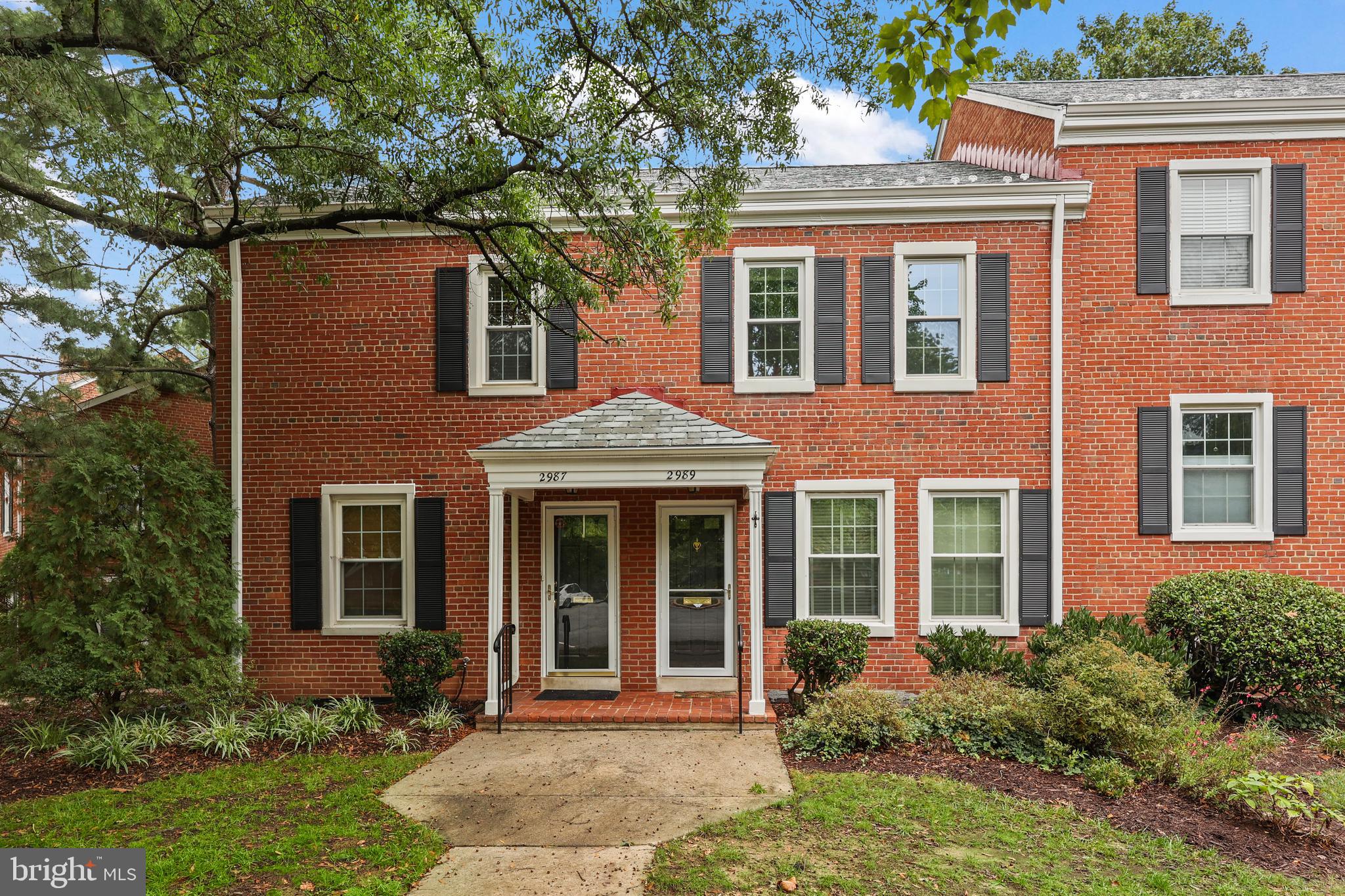 front view of a brick house with a yard