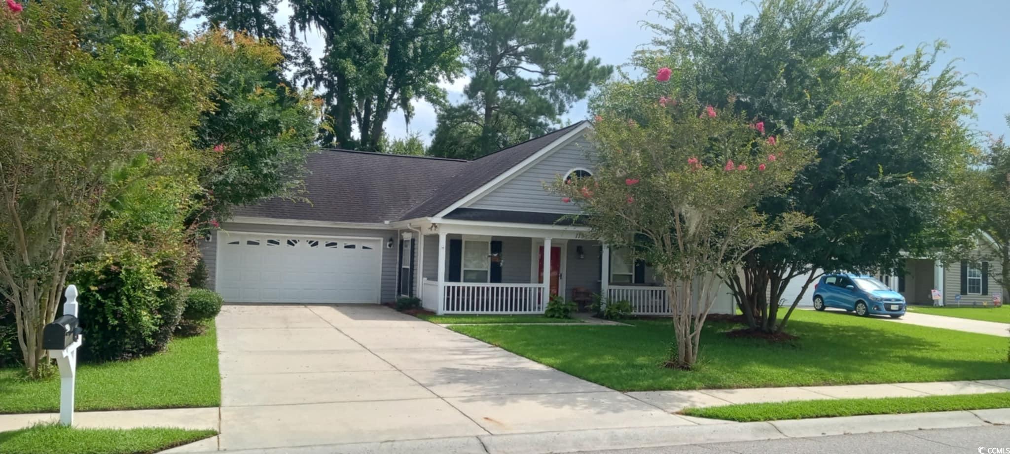 View of front facade featuring covered porch, a ga