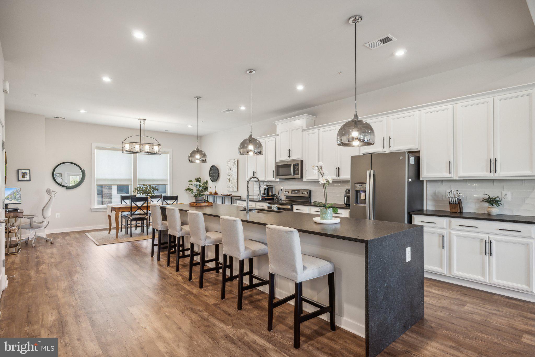 a large kitchen with a table and a refrigerator