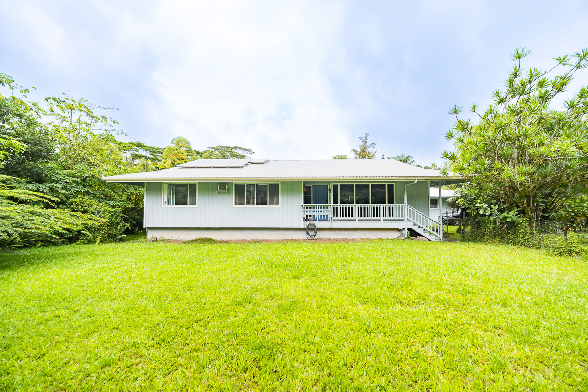 a front view of a house with swimming pool and porch with furniture