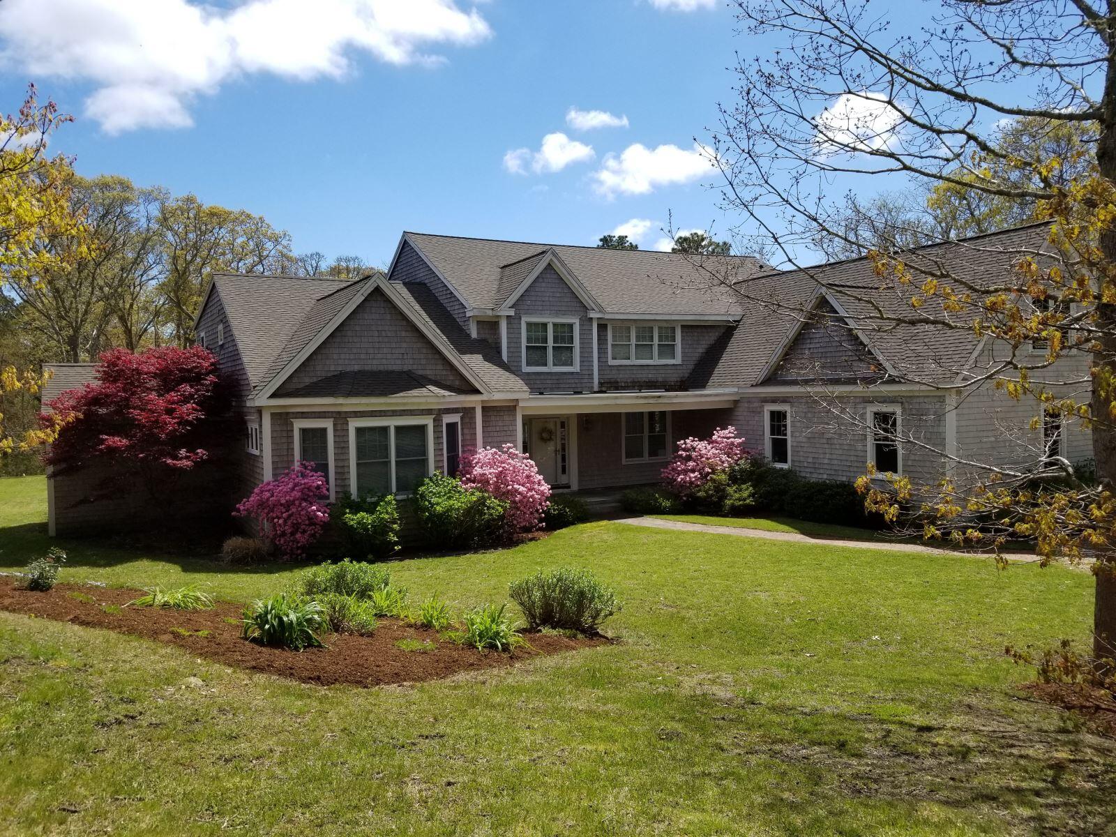 a front view of a residential houses with yard and green space