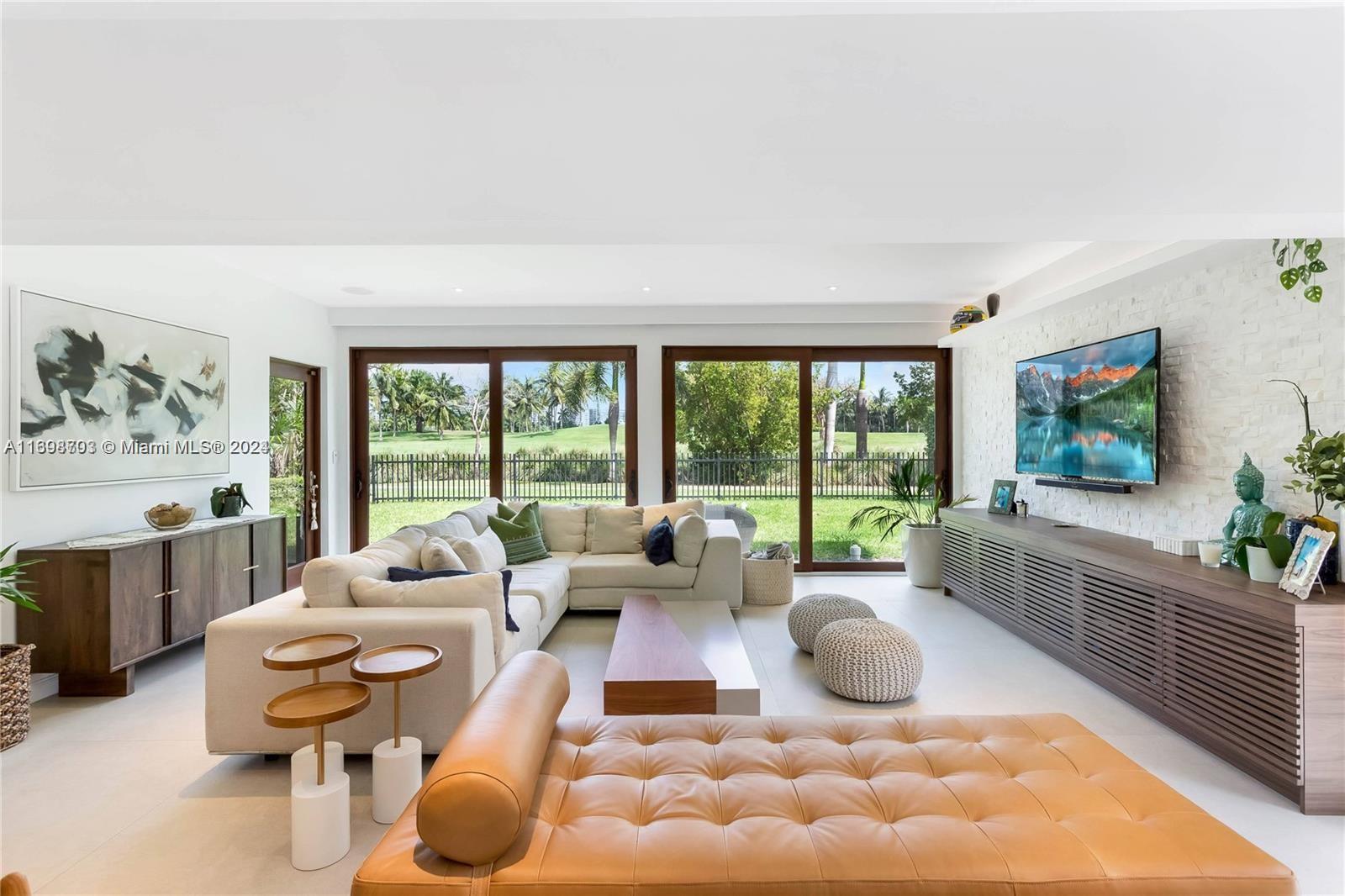 a living room with furniture large window and flat screen tv