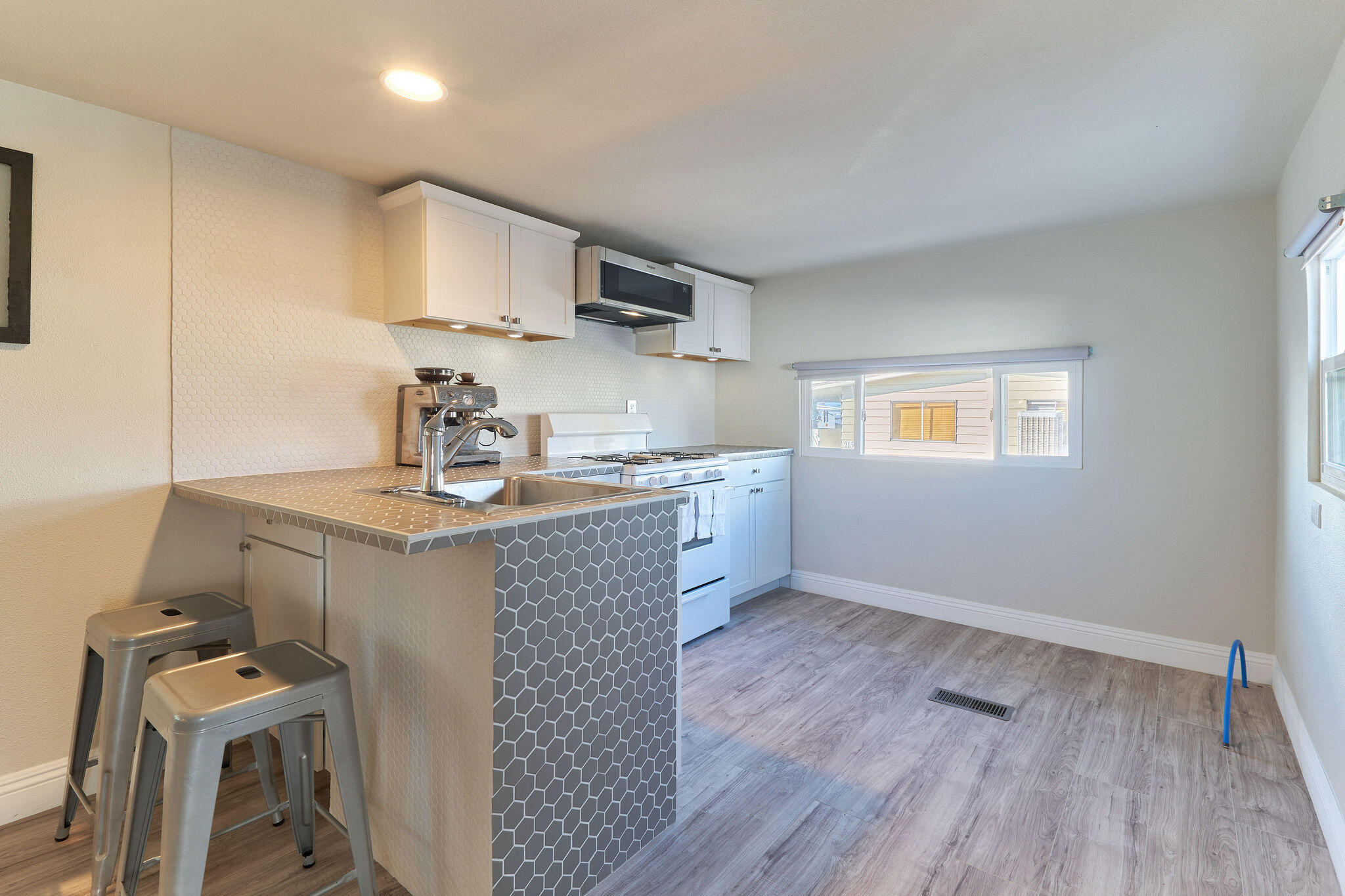 a kitchen with granite countertop a sink cabinets and wooden floor