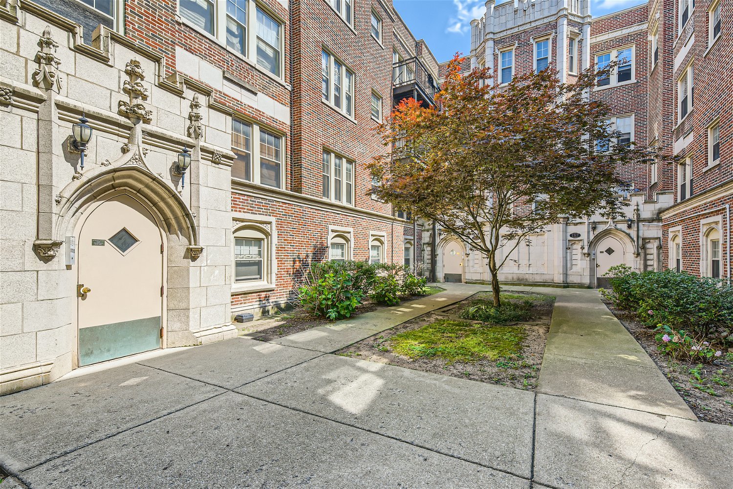 a front view of a multi story residential apartment building with yard