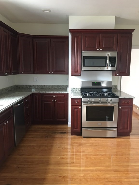 a kitchen with wooden cabinets a sink and stainless steel appliances