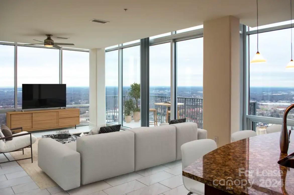 a living room with furniture tv and a large window