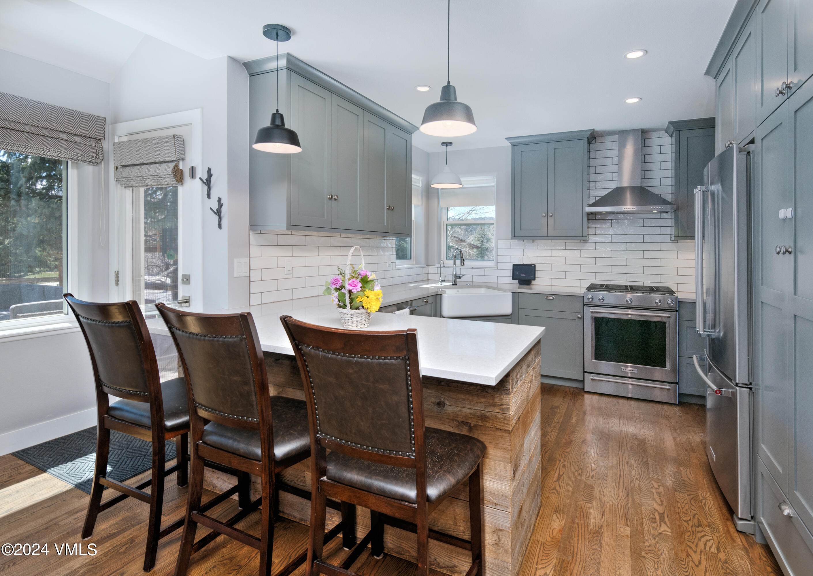 a kitchen with granite countertop kitchen island stainless steel appliances a dining table and chairs