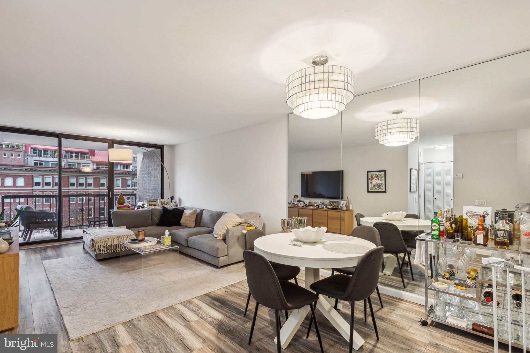 a living room with furniture a chandelier and a flat screen tv