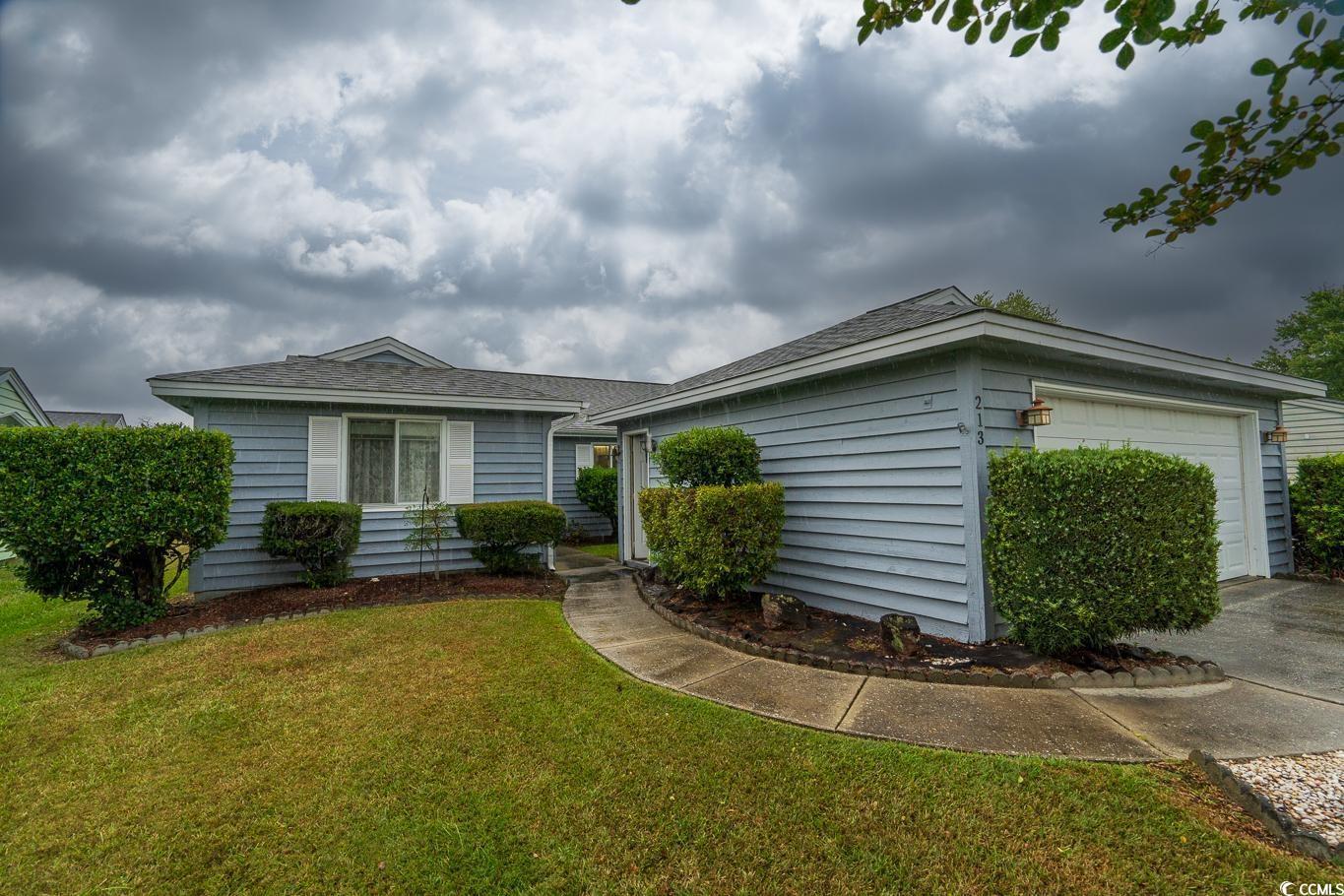 Ranch-style home featuring a garage, a front lawn,