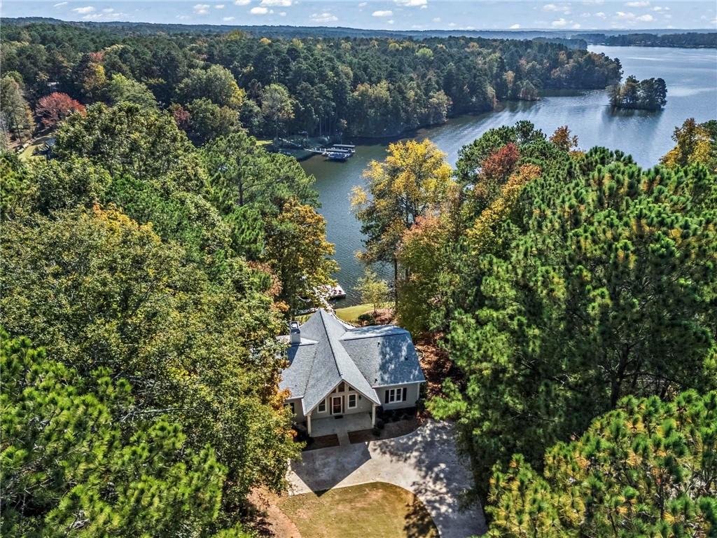 an aerial view of a house with a yard and a large tree