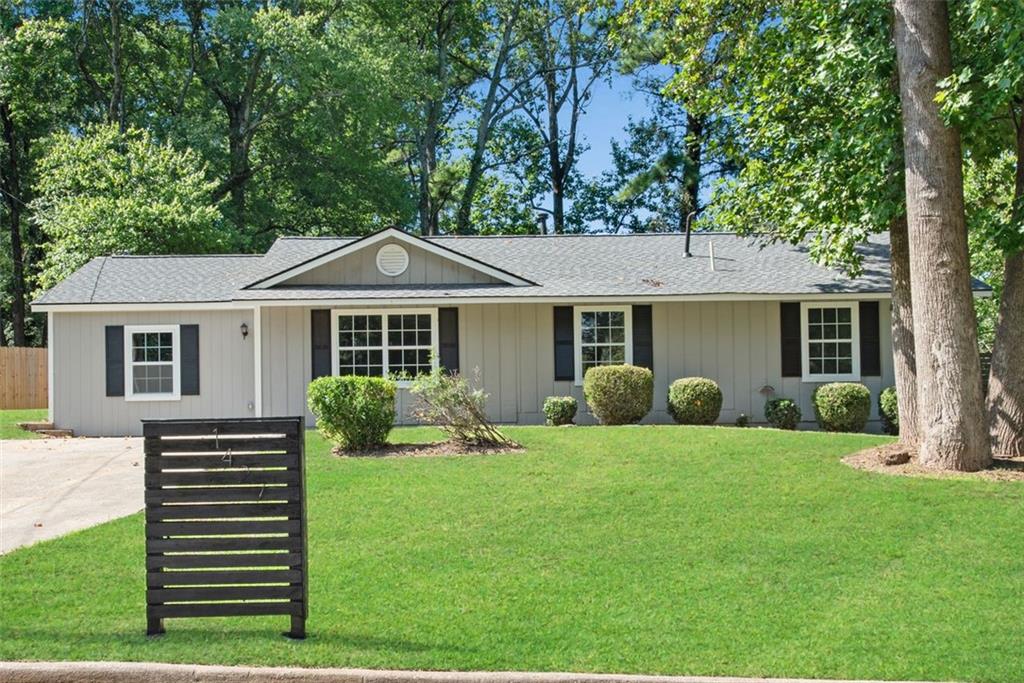 a front view of a house with a yard and green space