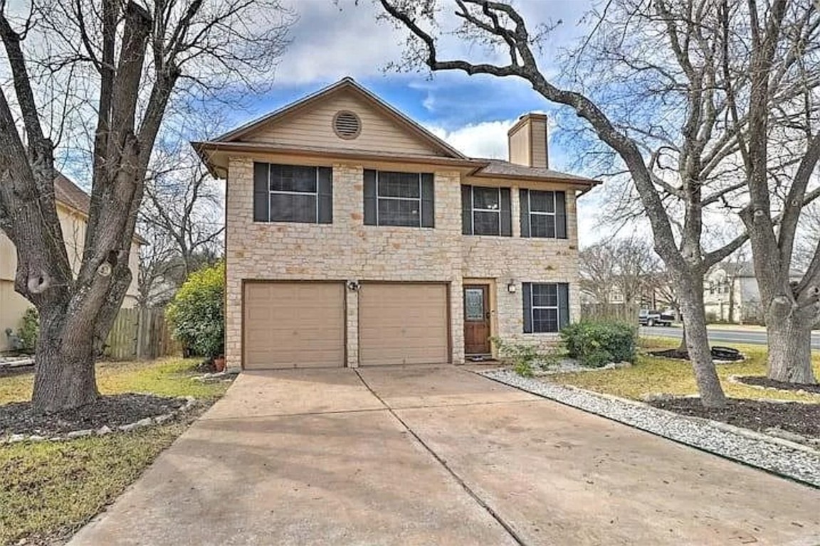 a front view of a house with a yard and trees