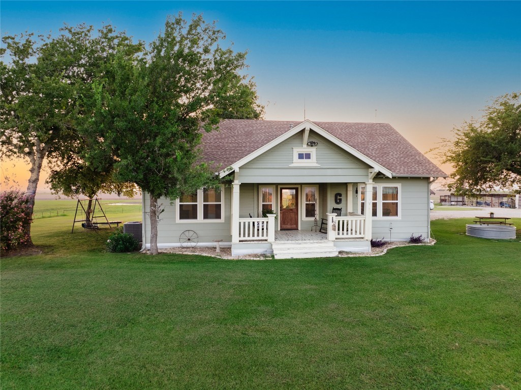 a front view of a house with a garden and trees