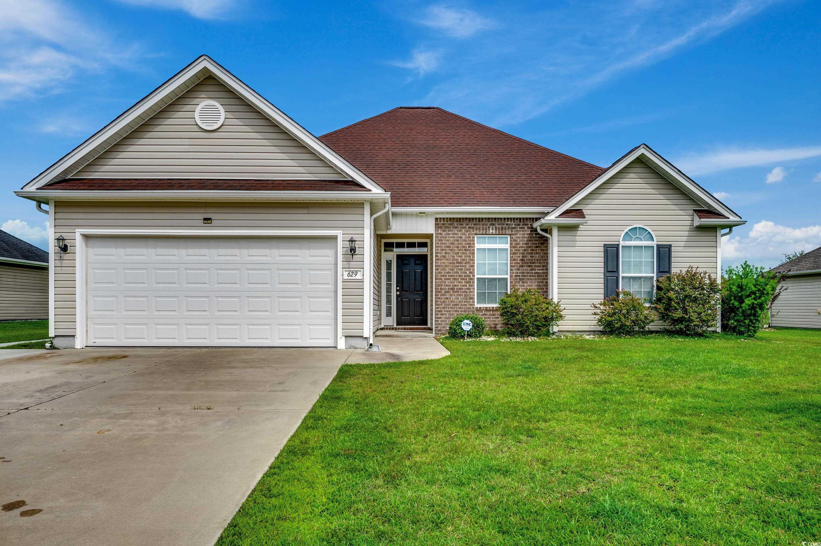 Single story home featuring a front lawn and a gar