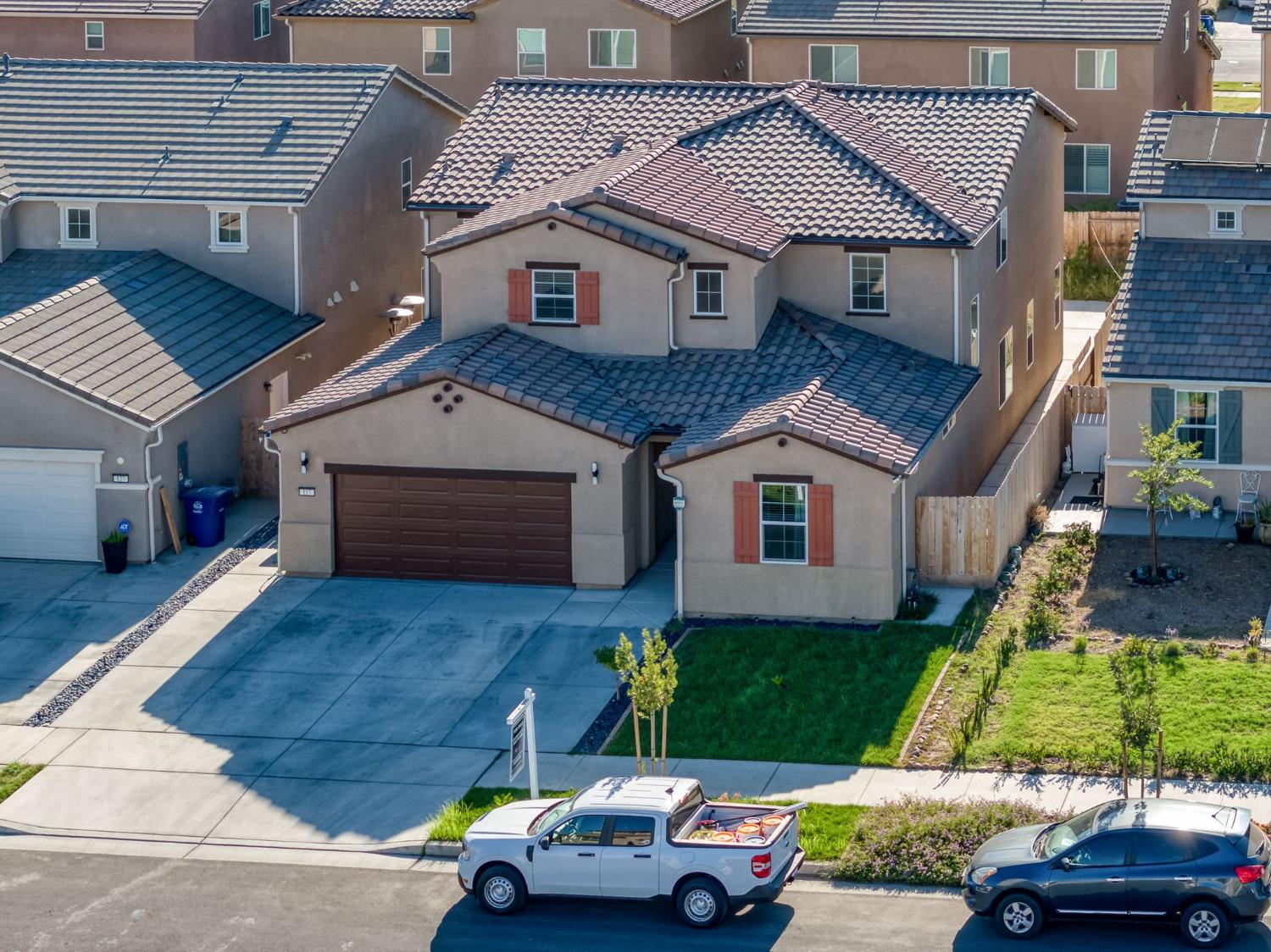 a car parked in front of a house with a yard